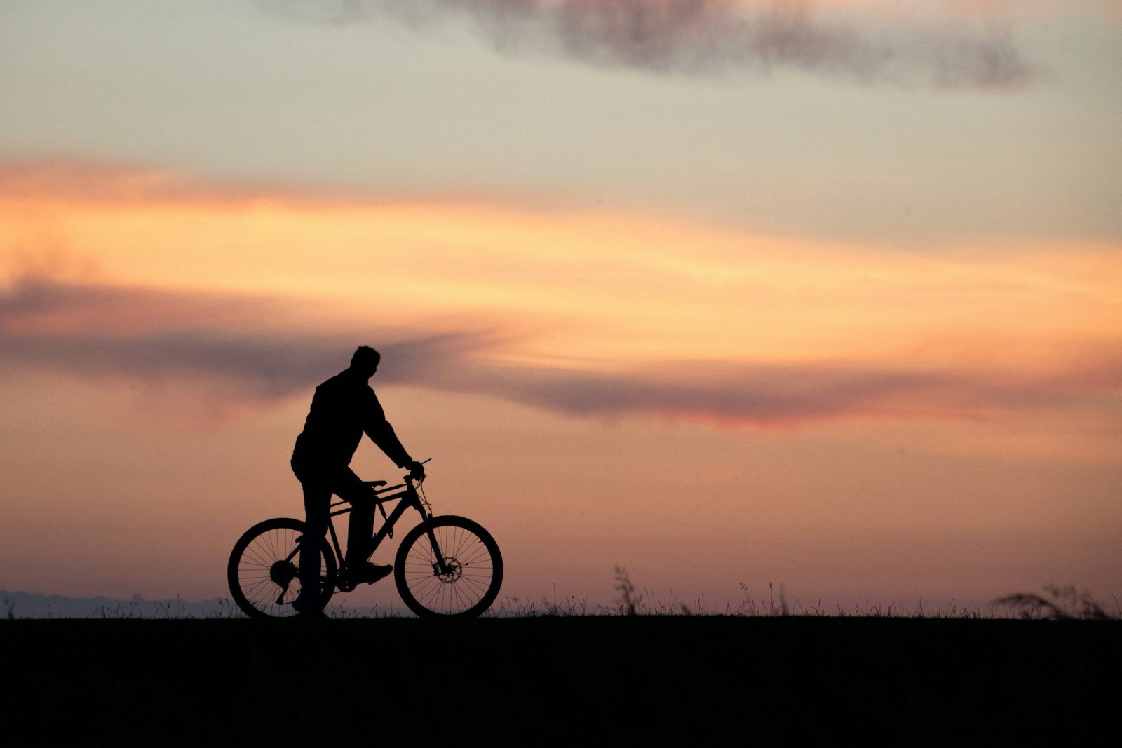 Cyclist riding uphill during sunset