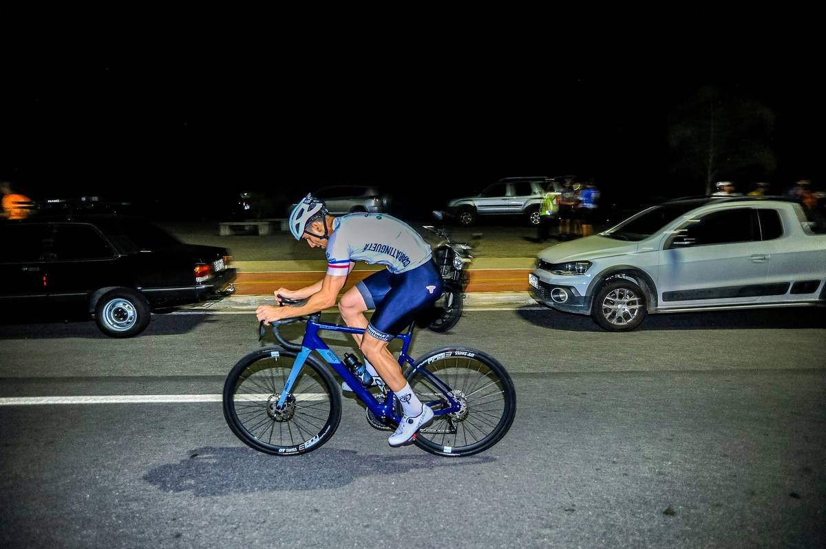 A cyclist training on an uphill road at sunrise