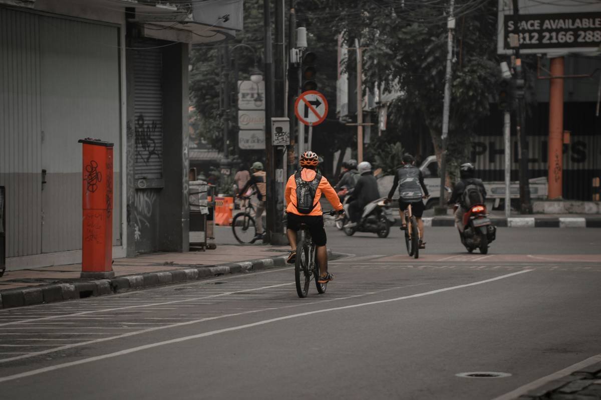 A person smiling next to their bicycle after losing weight