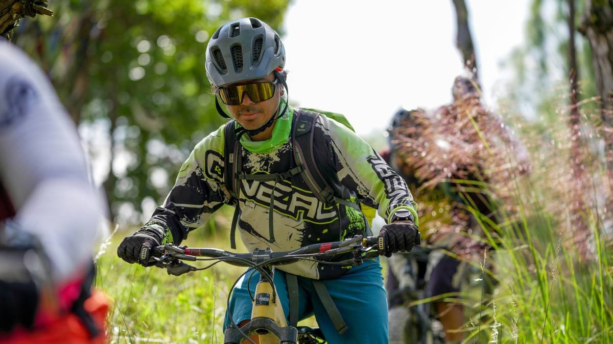 Close-up shot of cycling shoes clipped into pedals on a mountain road
