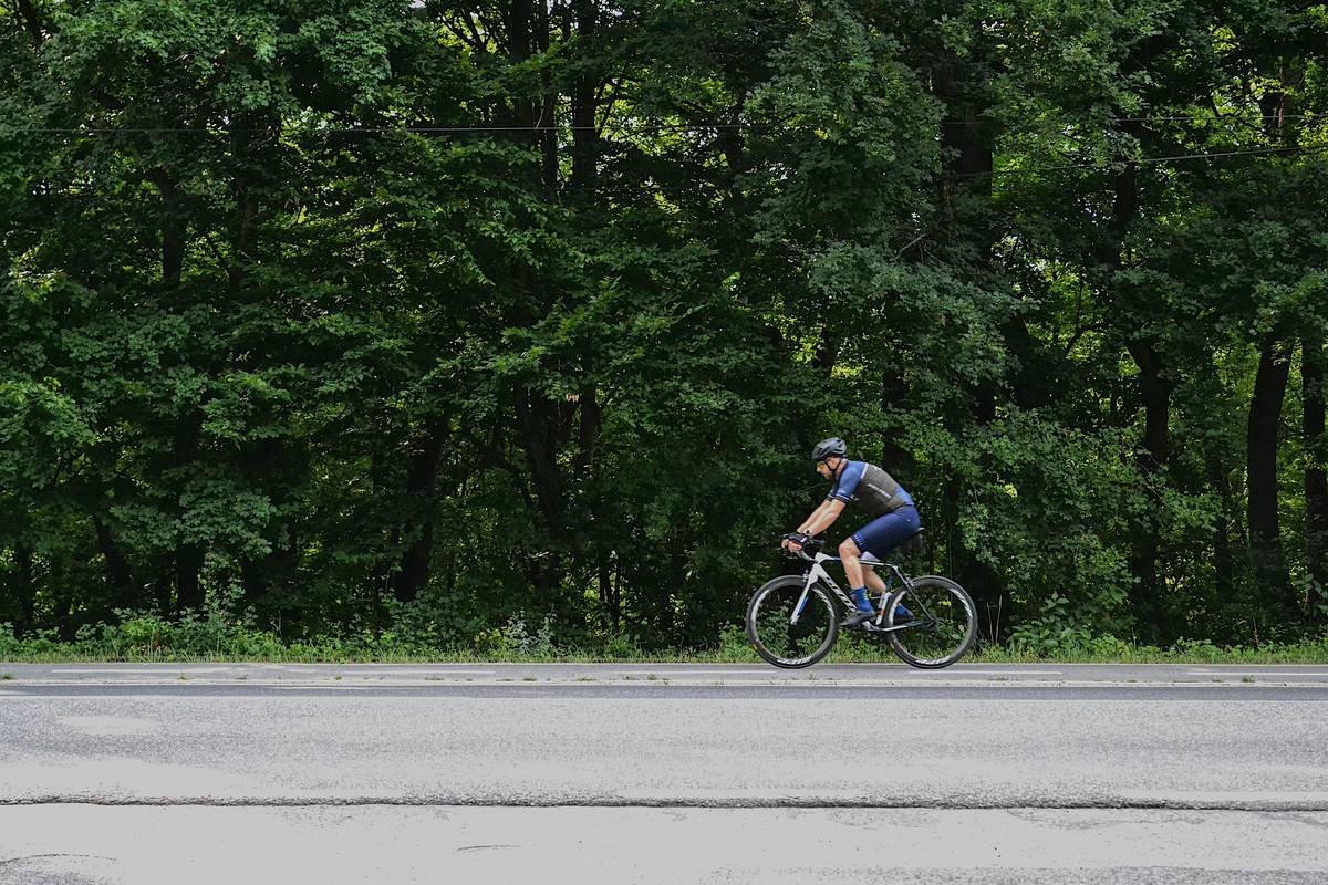 Sarah standing proudly next to her bike wearing athletic wear, smiling confidently.