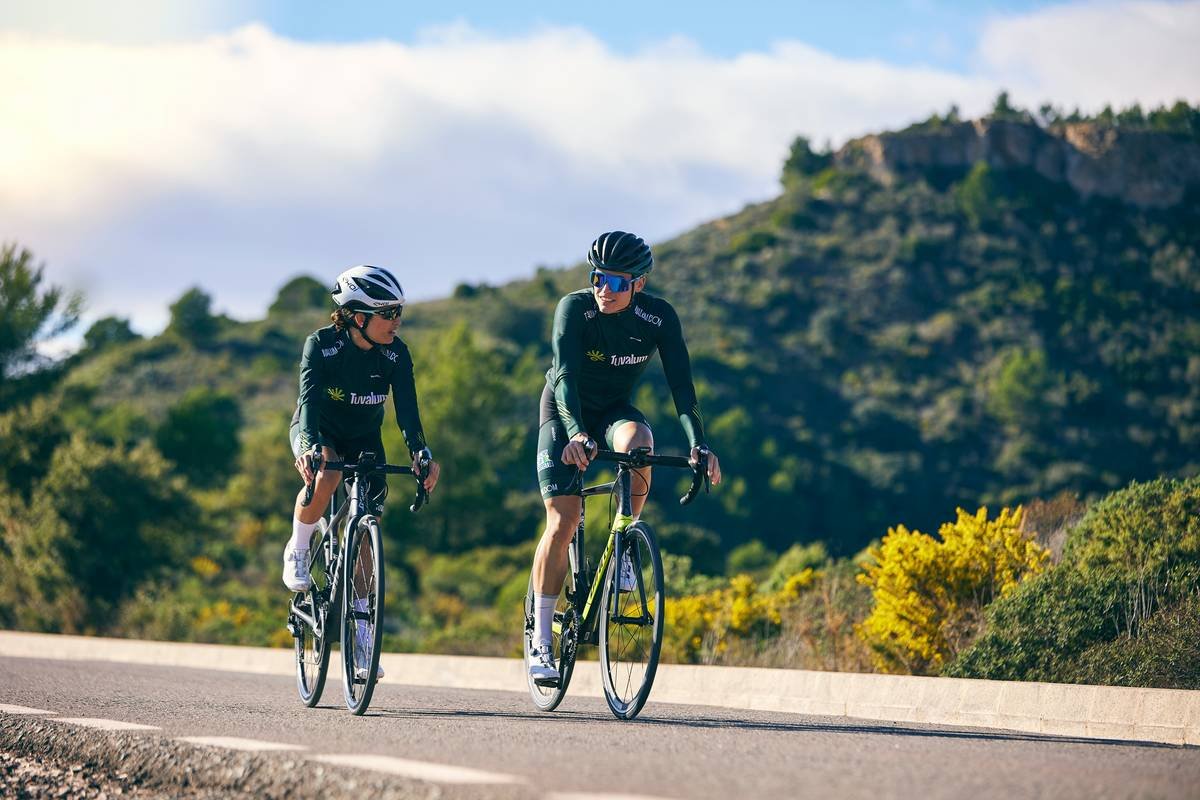 a couple of people riding bikes down a road