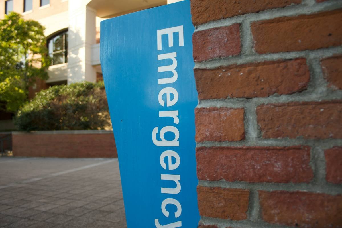 a blue emergency sign on a brick wall