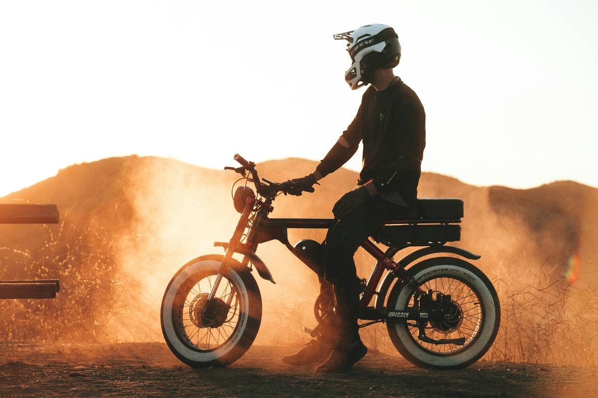 Male athlete riding electric bike through the mountains.