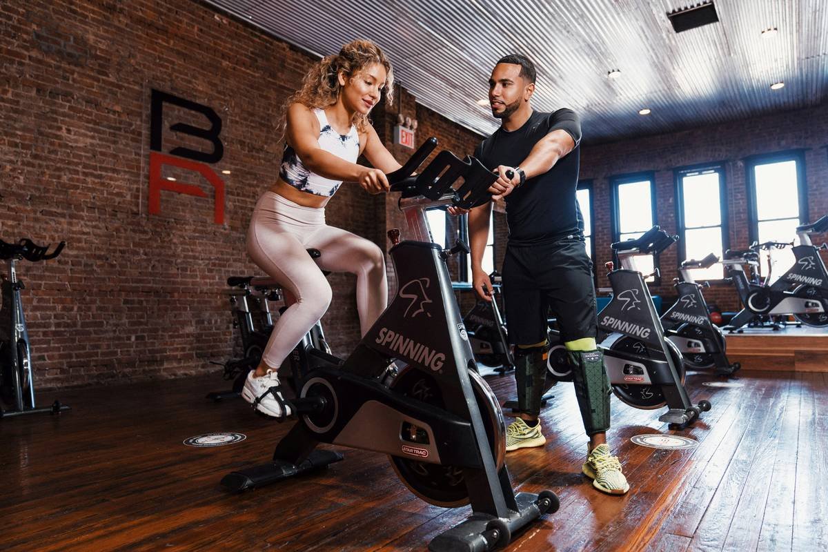 woman doing high-intensity bike burn cycling gym se weight session with sweat and focus